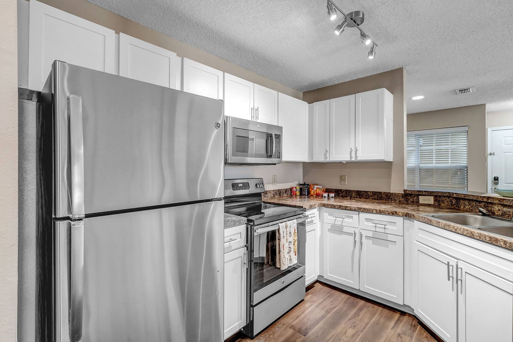Luxury apartment kitchen with stainless steel appliances, granite countertops, and lots of storage space